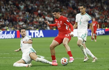El suizo Zeki Amdouni (c) avanza ante la marca de los argelinos Ramy Bensebaini y Aissa Mandi, en el juego que marcó el pase a los octavos de final del Mundial 2026 de los "relojeros".
EFE