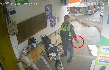 El suboficial ayudante Óscar Daniel Duarte López sostiene el cigarro de marihuana durante su guardia en el Mercado 4 de Asunción.