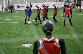 Robots humanoides de refuerzo juegan un partido de fútbol de exhibición durante una gira de prensa previa a los Juegos Mundiales de Robots Humanoides 2025, en Pekín, China.