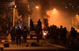 Integrantes de la Policía de Bolivia se enfrentan con manifestantes durante un desbloqueo de vías anoche, en Cochabamba (Bolivia).