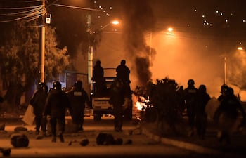 Integrantes de la Policía de Bolivia se enfrentan con manifestantes durante un desbloqueo de vías anoche, en Cochabamba (Bolivia).