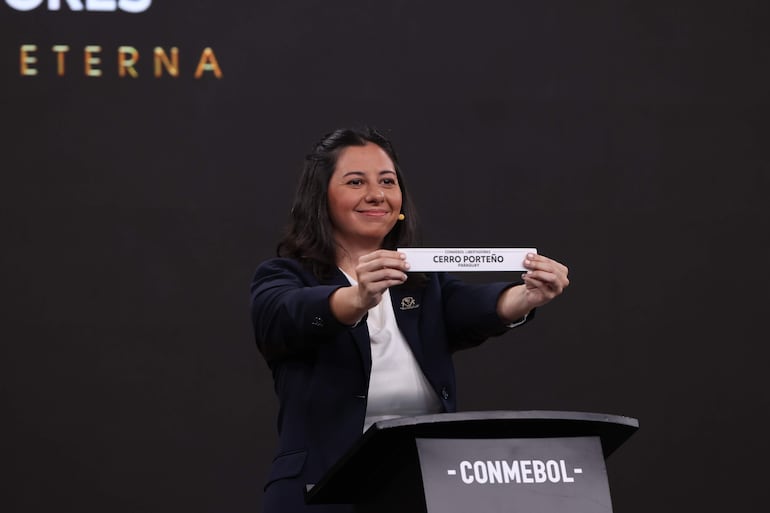 Luciana Antunes, representante de Conmebol, sostiene una papeleta con el nombre Cerro Porteño durante el sorteo de octavos de final de la Copa Libertadores 2026 en la sede dela Conmebol, en Luque, Paraguay.