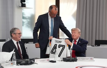 El presidente de Estados Unidos, Donald Trump (d) recibe una camiseta de Alemania con el número 47 de parte del canciller alemán, Friedrich Merz (C). Los acompaña el primer ministro del Reino Unido, Keir Starmer (i).