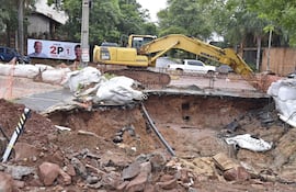Enorme agujero abierto sobre Nuestra Señora del Carmen casi Augusto Roa Bastos, Santo Domingo, Asunción. De fondo, la propaganda electoral del candidato oficialista, Camilo Pérez (ANR-HC).