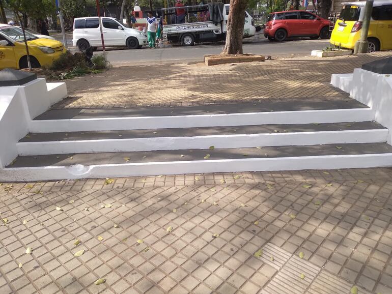 En vez de reparar el agujero existente en la escalerilla que da acceso a la plaza, la municipalidad optó por disimular el hoyo pintando todo con cal.