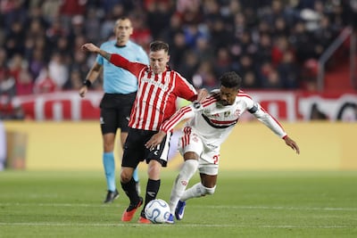 Ezequiel Piovi y Bruno Henrique pugnan por el balón, ante la atenta mirada del árbitro paraguayo Juan Gabriel Benítez, durante el partido de ida entre Estudiantes y Flamengo disputado la semana pasada en La Plata.