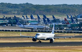 Un avión de Copa Airlines rueda en una pista mientras otros se sientan en la pista del Aeropuerto Internacional de Tocumen.