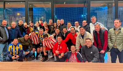 Santiago Peña sonríe con los asistentes, todos en camisetas de fútbol en un ambiente festivo y colorido.