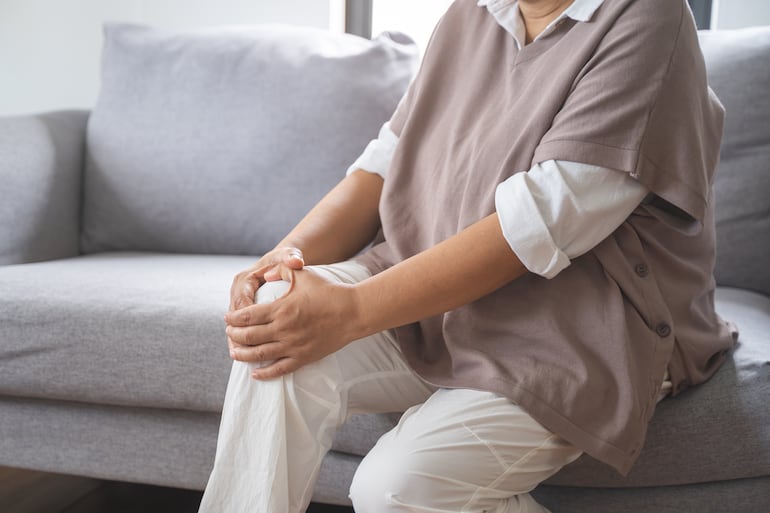 Mujer con dolor, debilidad o fragilidad en la rodilla.