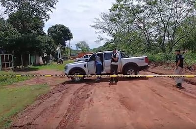 Hombres en chalecos oscuros y camiseta clara en una escena de allanamiento rodeada de vegetación y cinta de precaución.
