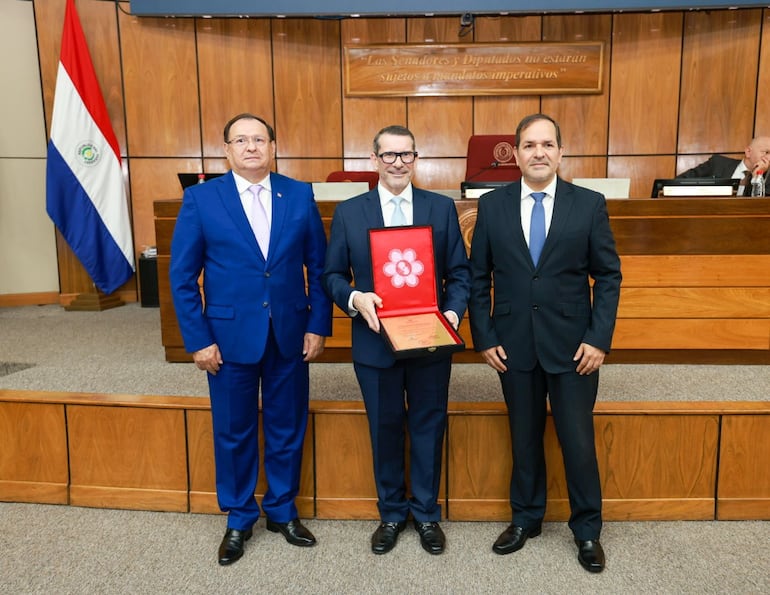 El Dr. Gustavo Ayala posa con su placa, acompañado del senador Remón Retamozo, vicepresidente primero de la Cámara de Senadores y el senador Arnaldo Samaniego, proponente del homenaje