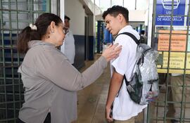 La directora del Instituto Nacional Albert Camus, Maribel de Figueroa, recibe a un estudiante, en San Salvador (El Salvador).