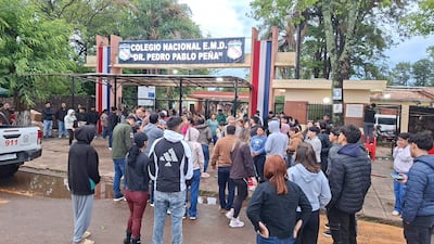 Multitud de electores en la entrada del Colegio Nacional Dr. Pedro P. Peña, algunos visiblemente frustrados y otros conversando en espera.