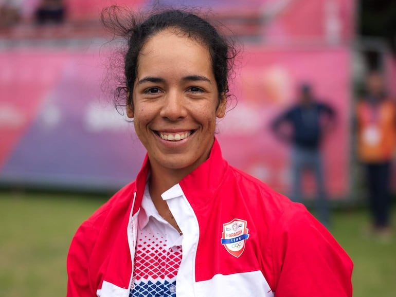 Sofía García sonríe con chaqueta roja y blanca del 'Paraguay Team', levantando ambos pulgares en un ambiente deportivo.