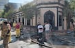 Grupo de bomberos en indumentaria especializada, manipulando mangueras, junto a civiles preocupados frente a la discoteca Nápoles.