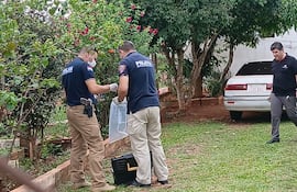 Agentes del Departamento de Criminalística levantan de la escena del crimen el revólver utilizado para el ataque.