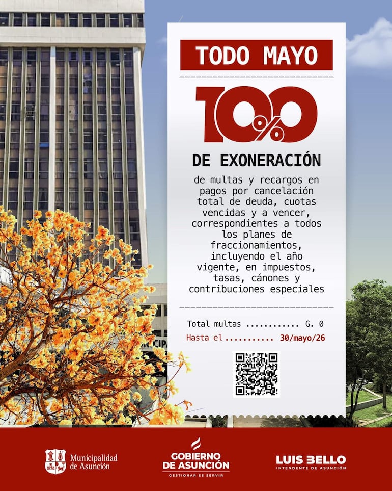 Cartel en la Municipalidad de Asunción sobre exoneración de multas, rodeado de un árbol con flores amarillas.