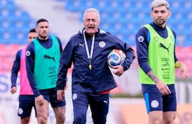 El entrenador de la selección paraguaya de fútbol, Gustavo Alfaro dirigiendo el entrenamiento albirrojo en medio de Antonio Sanabria y Julio Enciso.