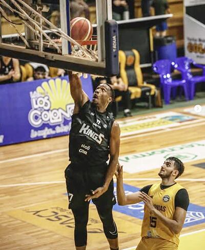 El americano Draper de los Kings convierte la canasta, ante el colono Juárez. 