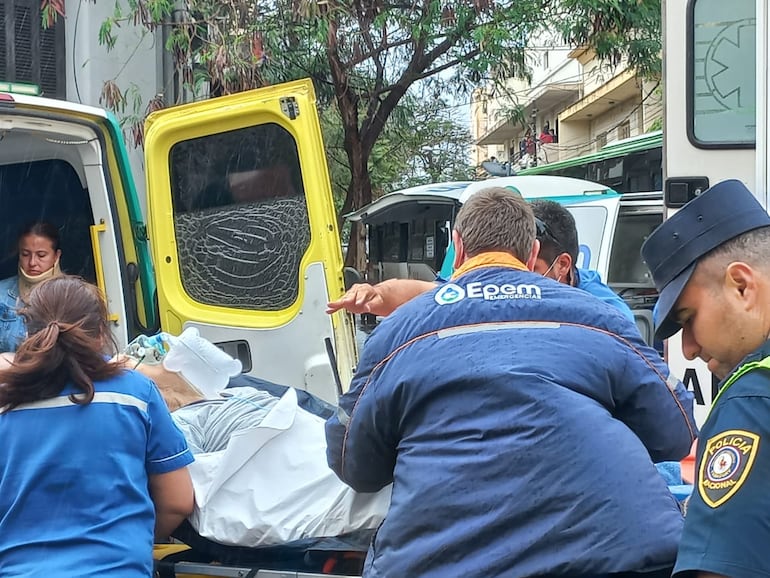 Los paramédicos proceden a trasladar al paciente de la ambulancia chocada a otra que vino al sitio para completar el viaje.