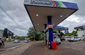 Estación de servicio Petropar bajo un cielo nublado, vehículos estacionados y en movimiento por la calle adyacente.