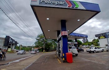 Estación de servicio Petropar bajo un cielo nublado, vehículos estacionados y en movimiento por la calle adyacente.