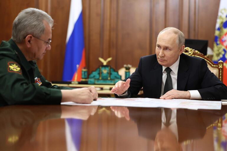 El presidente ruso Vladimir Putin (derecha) escucha al Ministro de Defensa ruso Sergei Shoigu durante una reunión en el Kremlin.