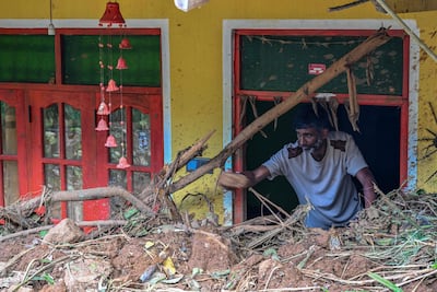 Un hombre dentro de una casa parcialmente enterrada por un deslizamiento de tierra causado por un ciclón en Sarasavigama, Sri Lanka.