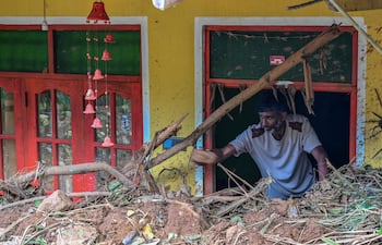 Un hombre dentro de una casa parcialmente enterrada por un deslizamiento de tierra causado por un ciclón en Sarasavigama, Sri Lanka.