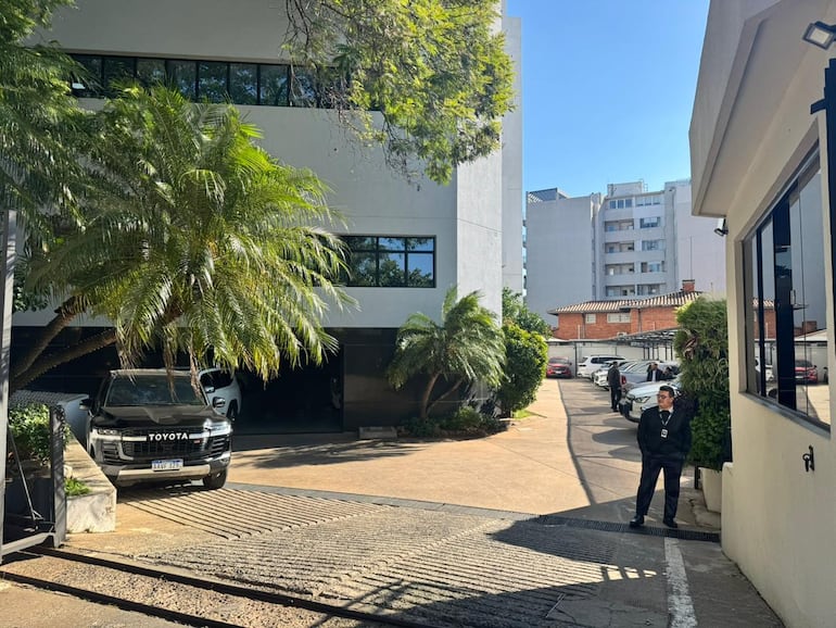 Un agente policial impide el acceso a la prensa mientras se desarrolla reunión con farmacéuticas.