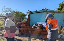 Un funcionario de la SEN registra los datos de la vivienda de Dolores Villordo, una de las afectadas por el temporal en el barrio 8 de Diciembre.