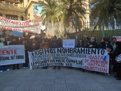 Grupo de manifestantes sosteniendo pancartas con mensajes de protesta, frente al Ministerio de Salud