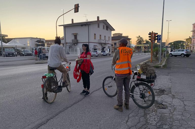Sindicalistas de la CGIL entregan información sobre derechos sindicales a un migrante indio que se dirige a trabajar a los campos de la zona.
