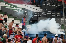 Los efectivos de la Policía Nacional lanzando los gases lacrimógenos a los integrantes de la barra brava de Cerro Porteño, en el enfrentamiento en el sector de Graderías Norte del estadio Defensores del Chaco.