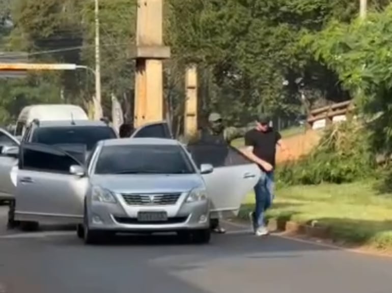 El que sería Nélido Javier Orué González, con ropa táctica, reduce a una de las víctimas del asalto de ayer en Ciudad del Este.