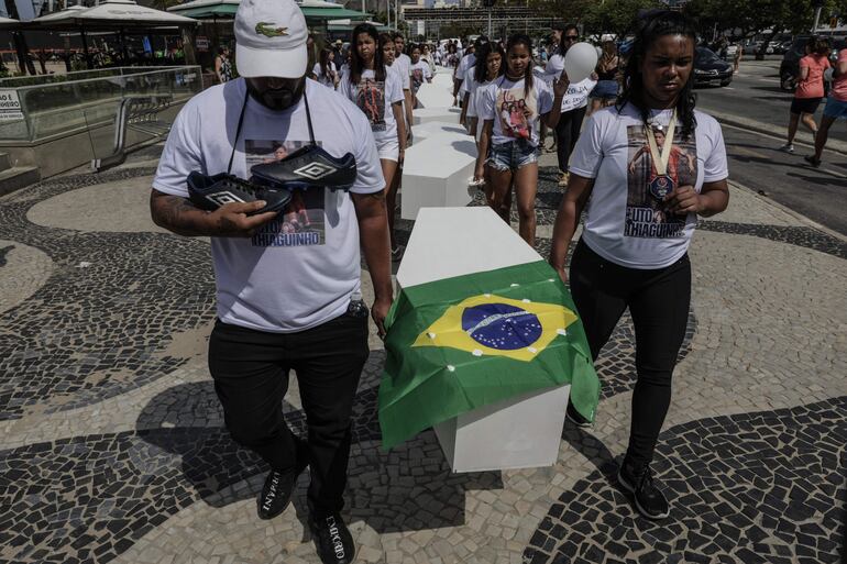 Los padres del jóven Thiago Menezes, Diogo Bezerra (i) y Priscila Menezes (d), participan en una protesta de la ONG Rio de Paz para homenajear a las víctimas civiles como consecuencia de las acciones policiales, hoy, en la playa de Copacabana, en Río de Janeiro (Brasil). 
