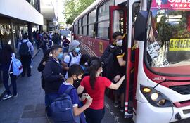 Estudiantes suben a un bus en el microcentro de Asunción.