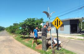 Los vecinos de una sector de la calle principal están en plena tarea de la colocación de los postes para la iluminación