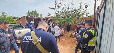 Efectivos policiales analizan la escena del crimen en busca de evidencias mientras el médico forense César González Haitter observa el cadáver de la víctima.