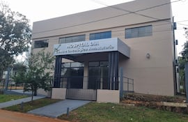 Edificio moderno del Centro Día Oncológico con letrero visible, rodeado de vegetación y vereda accesible.