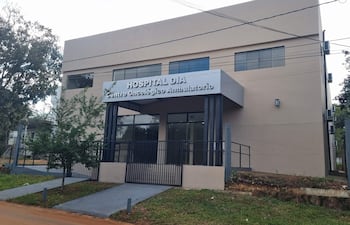 Edificio moderno del Centro Día Oncológico con letrero visible, rodeado de vegetación y vereda accesible.