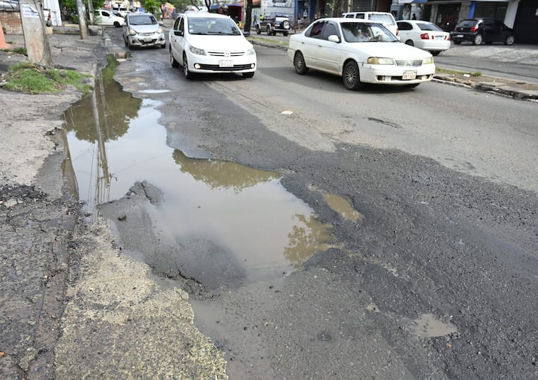 El asfalto sobre Fernando de la Mora y General Santos tiene enormes agujeros, tapados con agua servida.