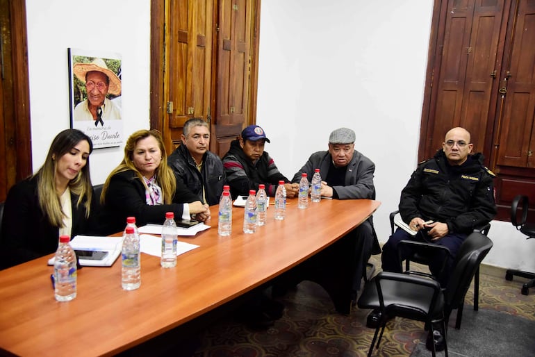 Cristina Solana Muñoz Ruivo habla mientras el grupo escucha atentamente, rodeados de documentos y botellas de agua en ambiente formal.