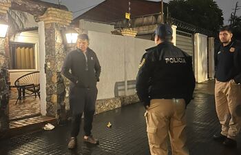 Agentes policiales de Investigaciones intercambian información frente a la residencia de Carlos José Vera Vera, donde se produjo el asalto domiciliario esta madrugada.