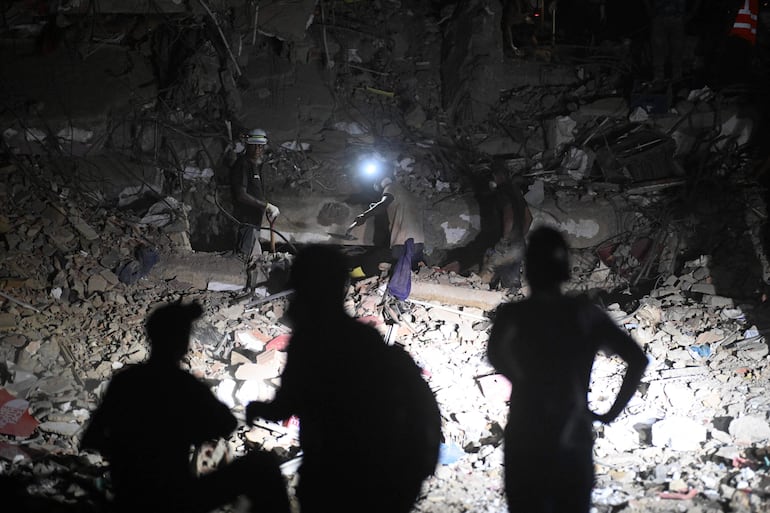 Equipos de rescate y voluntarios trabajan con linternas frontales durante operaciones nocturnas entre los escombros de un edificio colapsado en Caraballeda, estado de La Guaira, Venezuela, tras los terremotos del 24 de junio.