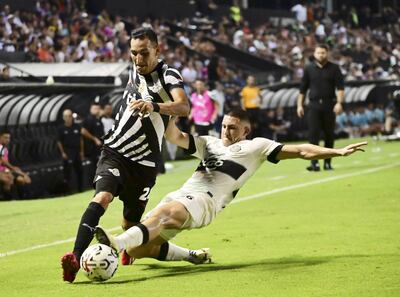 Marcelo Fernández (i), futbolista de Libertad, pelea por el balón con Facundo Zabala, jugador de Olimpia, en un partido por la undécima jornada del torneo Apertura 2024 del fútbol paraguayo en el estadio La Huerta, en Asunción.