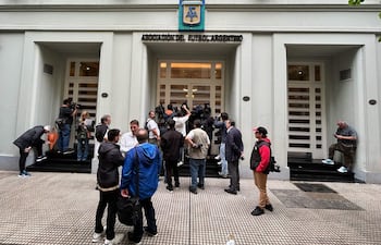 Periodistas miran desde afuera de la entrada de la sede de la Asociación del Fútbol Argentino (AFA). (Photo by JUAN MABROMATA / AFP)
