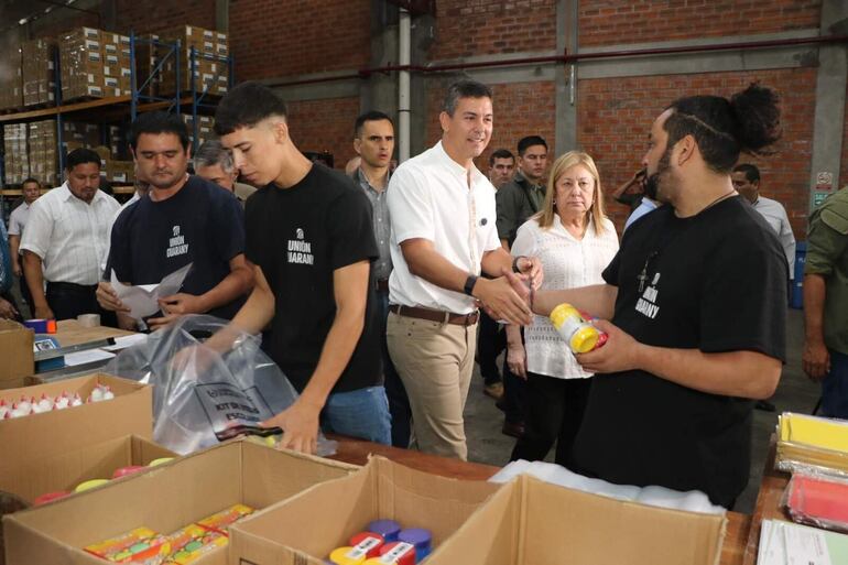 El presidente de la República, Santiago Peña, recorriendo el depósito de kits escolares. Escuelas de Cordillera, Paraguarí, Caaguazú y Central siguen sin los útiles.