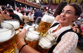 Una moza lleva cervezas el día de apertura de la 189.ª edición del tradicional festival de cerveza y diversión Oktoberfest en la capital bávara, Múnich, Alemania, el 21 de septiembre de 2024.