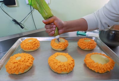 El repostero Jonathan Barrera prepara alimentos con forma de flor de cempasúchil este lunes, en Ciudad de México (México).